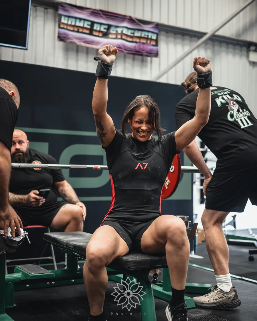 A lifter celebrating on the bench after a successful press